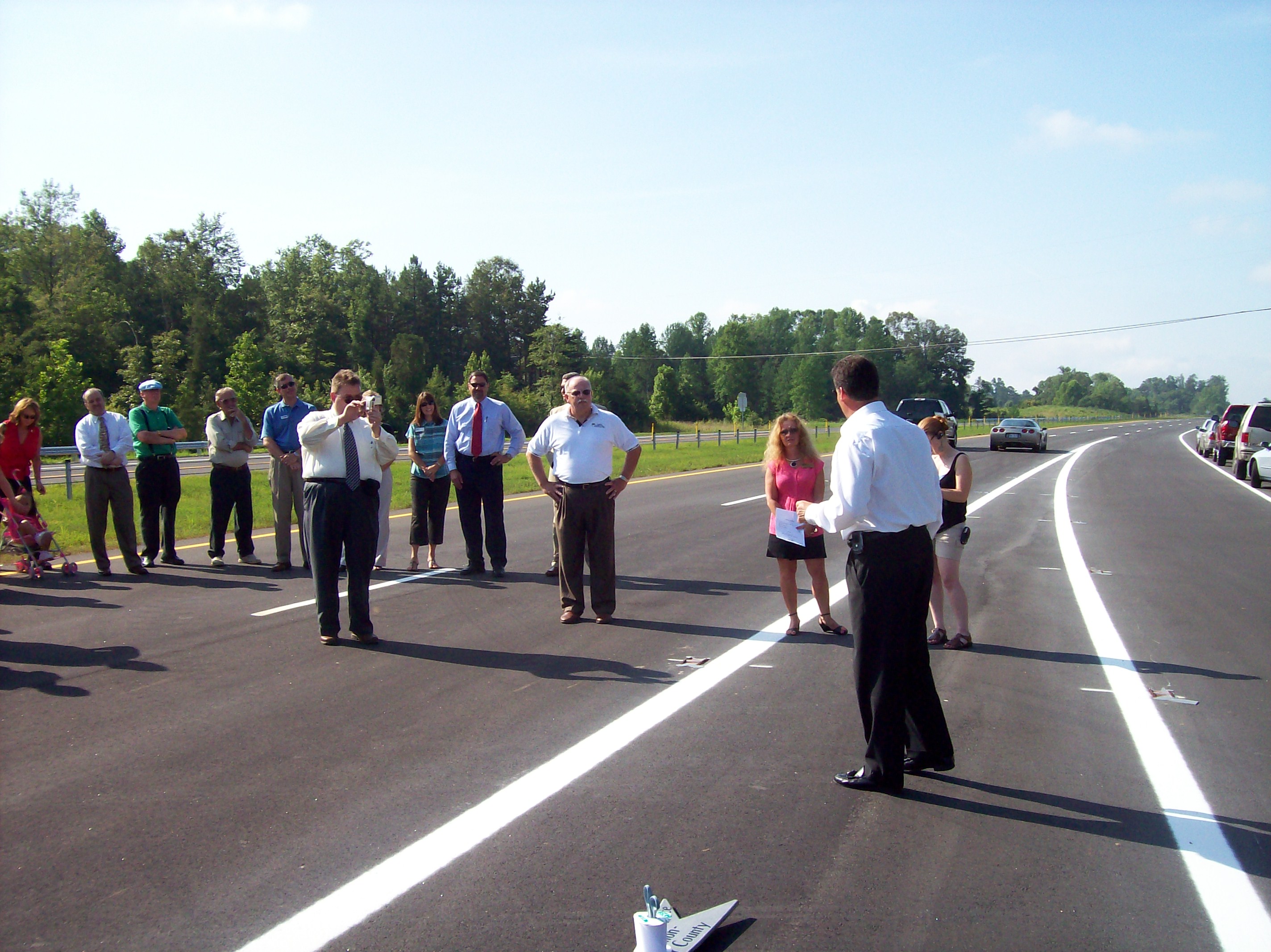 Man takes a picture of another man sitting in the